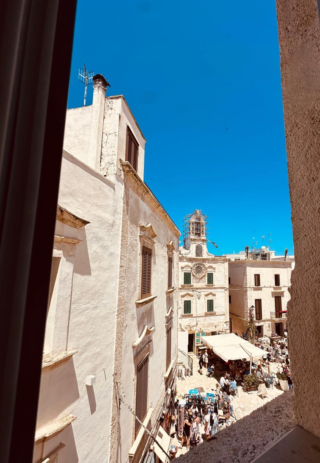 From a window, down to the piazza and the clock tower.