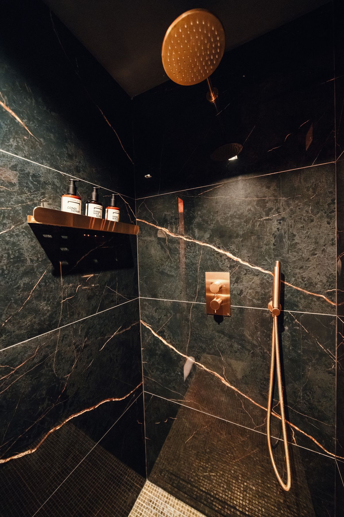 The black marble shower and its copper fittings.