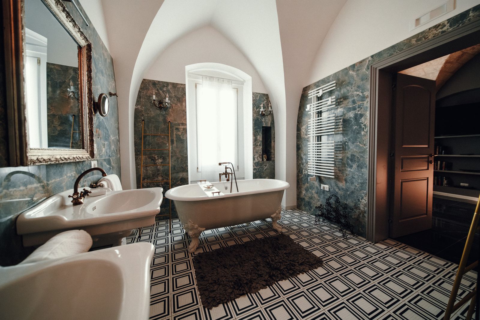 The free-standing tub against the green marble.